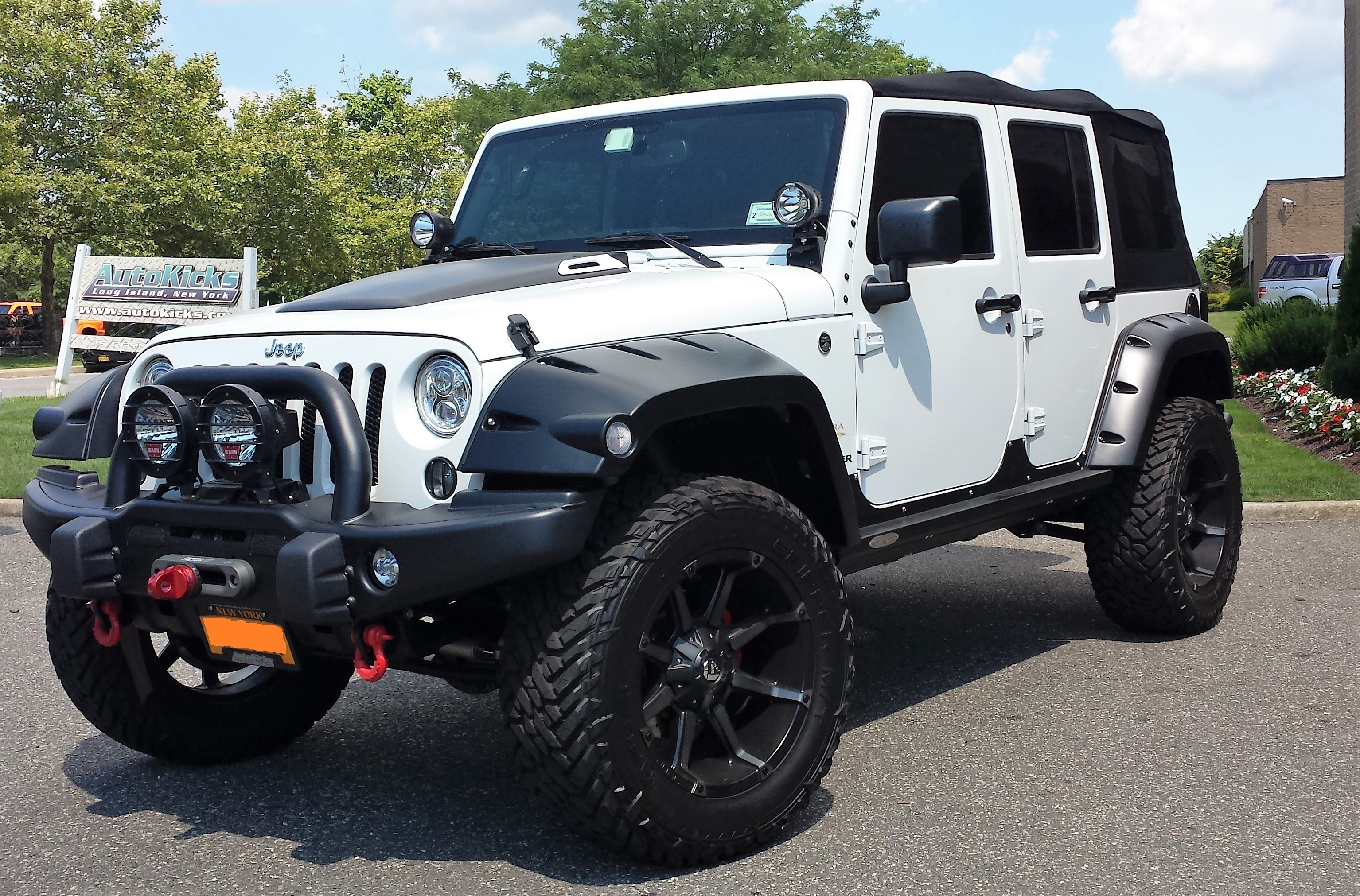 White Jeep lifted with wheel and tire package